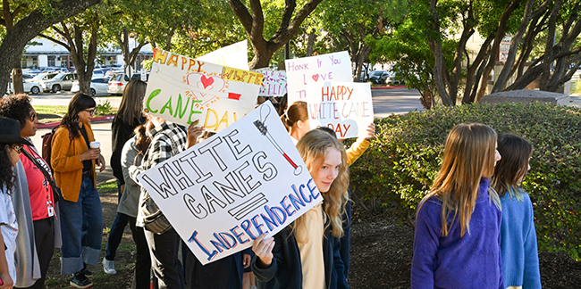 Children participating in a White Cane Day event carrying signs